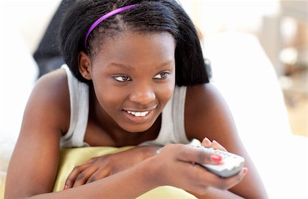 simsearch:400-04210845,k - Bright young woman watching TV lying on a sofa in the living-room Stock Photo - Budget Royalty-Free & Subscription, Code: 400-04182960