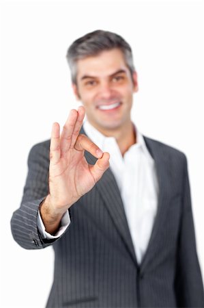 simsearch:400-04875087,k - Smiling mature businessman showing OK sign against a white background Photographie de stock - Aubaine LD & Abonnement, Code: 400-04183046