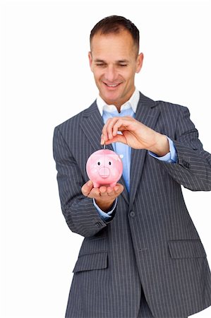 simsearch:400-04184165,k - Charismatic businessman saving money in a piggybank against a white background Stock Photo - Budget Royalty-Free & Subscription, Code: 400-04183846