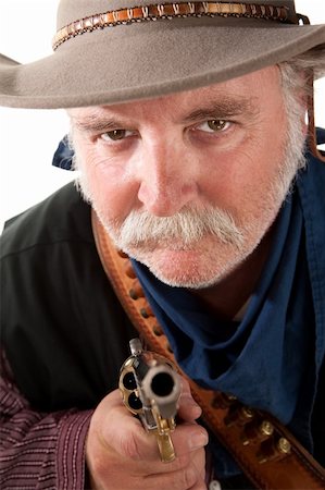 Mean looking cowboy pointing pisto towards camera Stock Photo - Budget Royalty-Free & Subscription, Code: 400-04194210