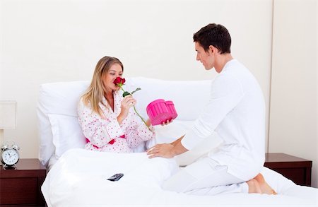 Handsome husband giving a present to his wife in the bedroom Photographie de stock - Aubaine LD & Abonnement, Code: 400-04195868