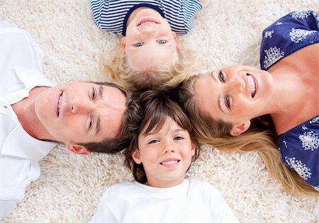 simsearch:400-04654755,k - Smiling young family lying on the floor with heads together Foto de stock - Super Valor sin royalties y Suscripción, Código: 400-04195970