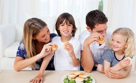 simsearch:400-04193348,k - Loving family eating burgers in the living room at home Stock Photo - Budget Royalty-Free & Subscription, Code: 400-04195990