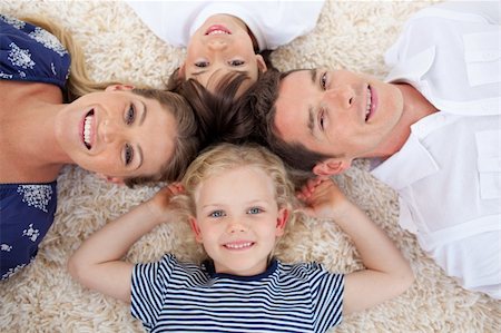simsearch:400-04654755,k - Smiling young family lying on the floor with heads together Foto de stock - Super Valor sin royalties y Suscripción, Código: 400-04196872
