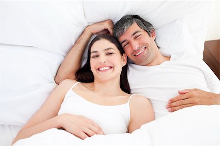 simsearch:400-04195864,k - Smiling couple hugging lying in their bed at home Stock Photo - Budget Royalty-Free & Subscription, Code: 400-04196894