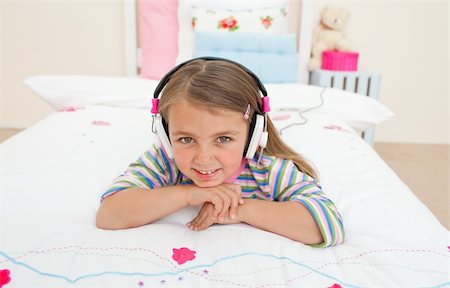 simsearch:400-05717451,k - Cute little gril listening to music lying on her bed Stock Photo - Budget Royalty-Free & Subscription, Code: 400-04196978