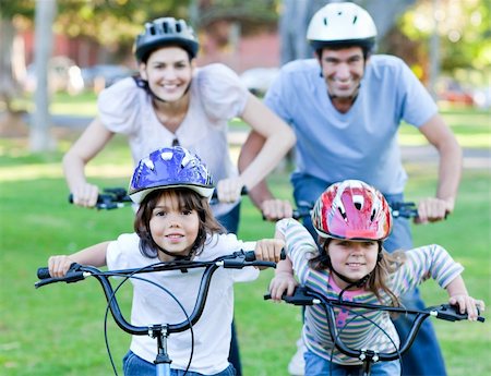 simsearch:400-05755734,k - Happy family riding a bike in a park Photographie de stock - Aubaine LD & Abonnement, Code: 400-04197015