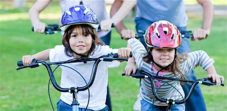 simsearch:400-05755734,k - Jolly children riding a bike in a park Photographie de stock - Aubaine LD & Abonnement, Code: 400-04197016