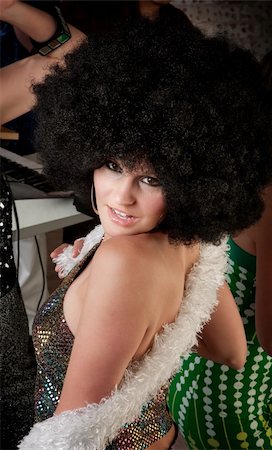 simsearch:400-04206686,k - Pretty girl with afro wig and boa at a 1970s Disco Music Party Stock Photo - Budget Royalty-Free & Subscription, Code: 400-04197149