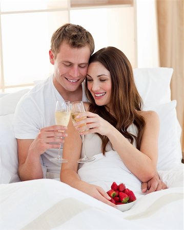 simsearch:400-04195864,k - Cheerful couple drinking champagne with strawberries lying in bed at home Stock Photo - Budget Royalty-Free & Subscription, Code: 400-04197309