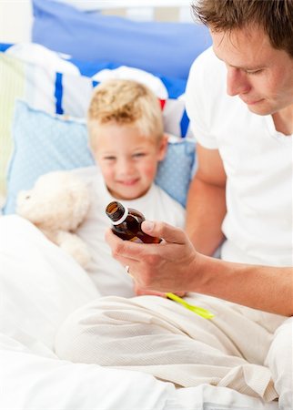 feeble - Charming father giving cough syrup to his sick son sitting on bed Photographie de stock - Aubaine LD & Abonnement, Code: 400-04197363