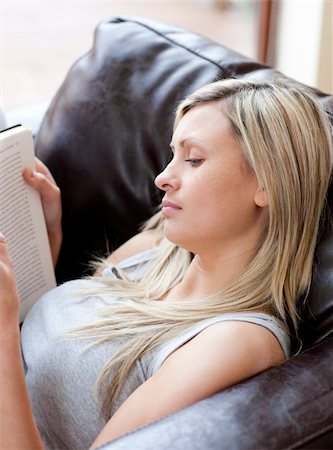 simsearch:400-04418460,k - Concentrated woman reading a book sitting on a sofa in a living-room Stock Photo - Budget Royalty-Free & Subscription, Code: 400-04198601