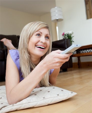 simsearch:400-04210845,k - Laughing woman watching TV lying on the floor in the living-room Stock Photo - Budget Royalty-Free & Subscription, Code: 400-04198714