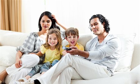 simsearch:400-04193348,k - Excited little boy watching TV with his family sitting on a sofa Stock Photo - Budget Royalty-Free & Subscription, Code: 400-04198774