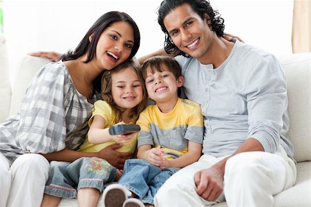 simsearch:400-04193348,k - Cute family watching TV together sitting on a sofa at home Stock Photo - Budget Royalty-Free & Subscription, Code: 400-04198776