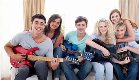 simsearch:400-04199223,k - Group of teenagers playing guitar at home together Stock Photo - Budget Royalty-Free & Subscription, Code: 400-04199228