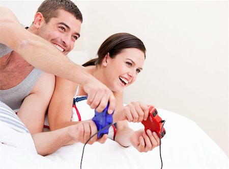simsearch:400-04195864,k - Happy couple playing video games against a white background Stock Photo - Budget Royalty-Free & Subscription, Code: 400-04190032