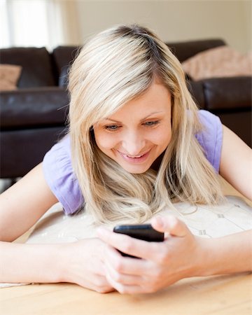 simsearch:400-04212823,k - Bright woman sending a text in the living-room Stock Photo - Budget Royalty-Free & Subscription, Code: 400-04190795