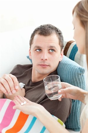 feeble - Beautiful woman give medicine to her husband her husband at home Photographie de stock - Aubaine LD & Abonnement, Code: 400-04190820