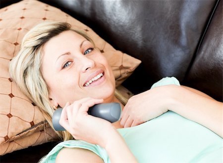 simsearch:400-04210845,k - Happy woman using a remote in the living-room Stock Photo - Budget Royalty-Free & Subscription, Code: 400-04190963