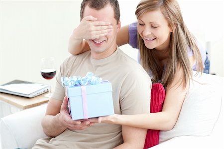 simsearch:400-04195864,k - Smiling woman giving a present to her boyfriend in the living-room Stock Photo - Budget Royalty-Free & Subscription, Code: 400-04191740