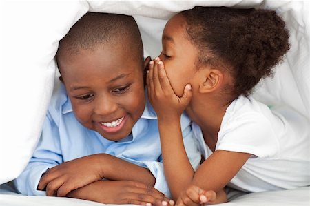 pictures of a little girl whispering - Ethnic little girl whispering something to her brother under the cover Stock Photo - Budget Royalty-Free & Subscription, Code: 400-04192413