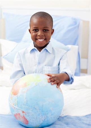 Cute little boy holding a terrestrial globe lying on his bed Stock Photo - Budget Royalty-Free & Subscription, Code: 400-04192473