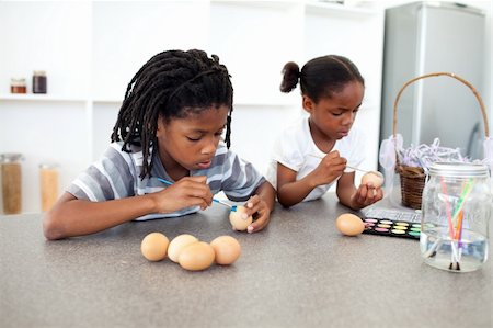 Concentrated Afro-american siblings painting eggs in the kitchen Stock Photo - Budget Royalty-Free & Subscription, Code: 400-04192501