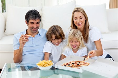 simsearch:400-04193348,k - Positive family eating pizzas sitting on sofa Stock Photo - Budget Royalty-Free & Subscription, Code: 400-04193249