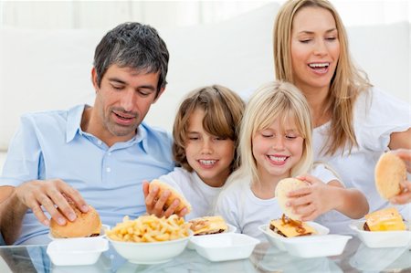simsearch:400-04193348,k - Loving family eating hamburgers sitting on sofa Stock Photo - Budget Royalty-Free & Subscription, Code: 400-04193254