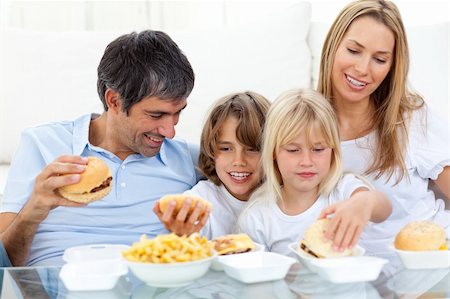 simsearch:400-04193348,k - Joyful family eating hamburgers sitting on sofa Stock Photo - Budget Royalty-Free & Subscription, Code: 400-04193251