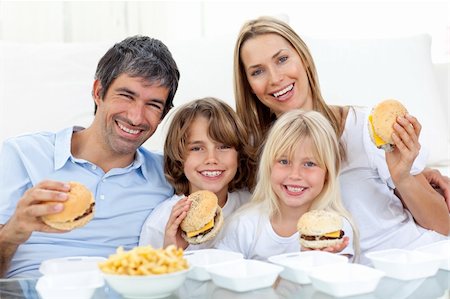 simsearch:400-04193348,k - Happy family eating hamburgers sitting on the floor at home Stock Photo - Budget Royalty-Free & Subscription, Code: 400-04193348