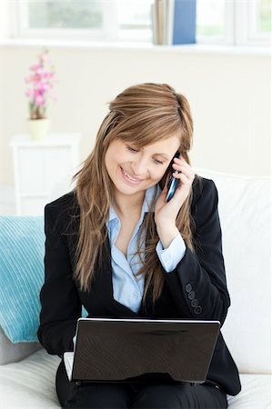 simsearch:400-04212823,k - Glowing businesswoman using her phone and laptop in her living room Stock Photo - Budget Royalty-Free & Subscription, Code: 400-04204128