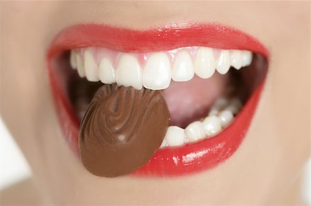 simsearch:400-04932642,k - Chocolate sweet in beautiful woman mouth macro Photographie de stock - Aubaine LD & Abonnement, Code: 400-04205464
