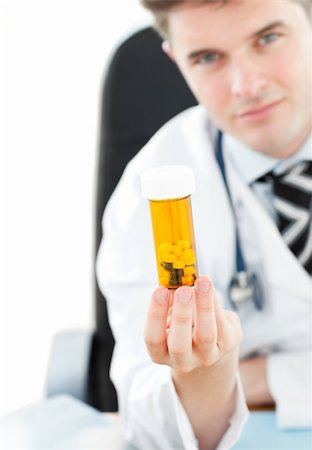 simsearch:6109-06005907,k - Young doctor holding pills in his office Stock Photo - Budget Royalty-Free & Subscription, Code: 400-04205544