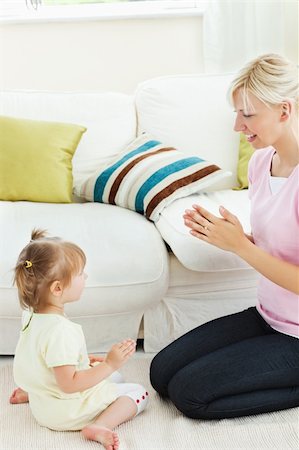 Pretty mother playing with her enthusiastic daughter in living room Stock Photo - Budget Royalty-Free & Subscription, Code: 400-04206210