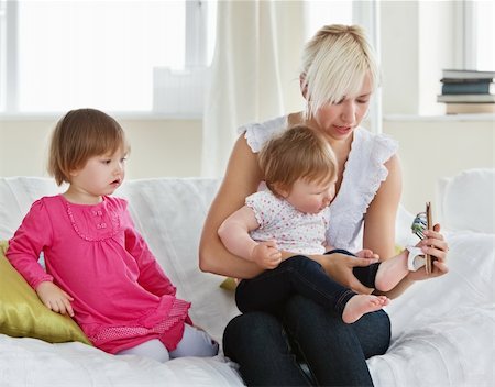 Smiling mother playing with her daughters in living room Stock Photo - Budget Royalty-Free & Subscription, Code: 400-04206233