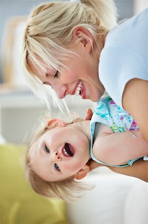 Simper mother playing with her daughter in living room Stock Photo - Budget Royalty-Free & Subscription, Code: 400-04206250