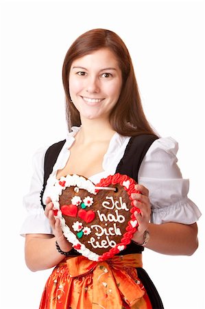 Woman in love dressed with Oktoberfest dirndl holding gingerbread heart. Isolated on white background. Stock Photo - Budget Royalty-Free & Subscription, Code: 400-04206411