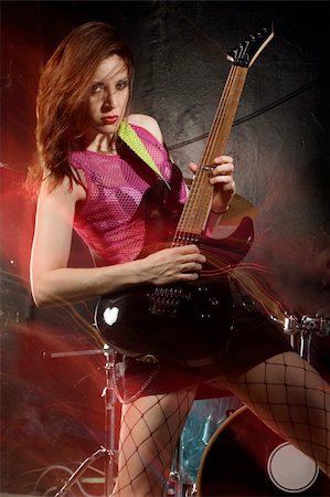 simsearch:400-04652753,k - Photo of a female guitarist playing on a stage. Shot with strobes and slow shutter speed to create lighting atmosphere and blur effects. Slight motion blur on performer. Stock Photo - Budget Royalty-Free & Subscription, Code: 400-04206545