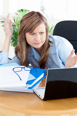 simsearch:400-04281575,k - Irritated businesswoman looking at her laptop sitting in her office Stock Photo - Budget Royalty-Free & Subscription, Code: 400-04208053