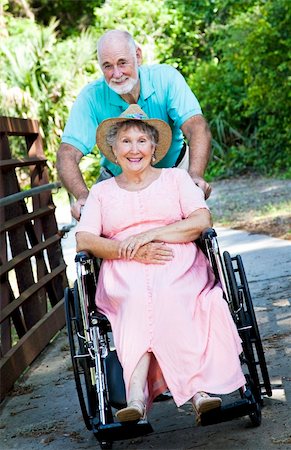 simsearch:400-04208630,k - Senior man pushing his disabled wife through the park in a wheelchair. Stock Photo - Budget Royalty-Free & Subscription, Code: 400-04208606