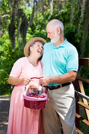 simsearch:400-04208630,k - Senior couple carrying a picnic basket and laughing together. Stock Photo - Budget Royalty-Free & Subscription, Code: 400-04208610