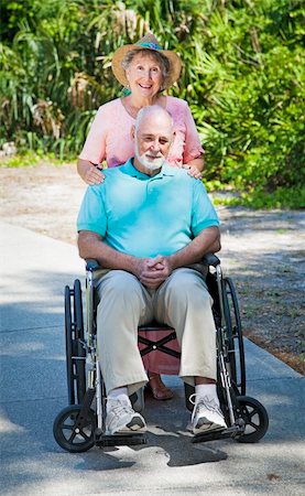 simsearch:400-04208630,k - Senior lady pushing her husband in his wheelchair. Stock Photo - Budget Royalty-Free & Subscription, Code: 400-04208620