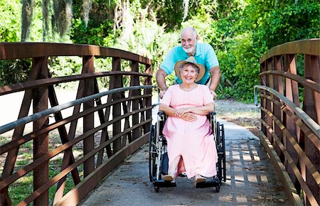 simsearch:400-04208630,k - Senior man pushes his disabled wife through the park in a wheelchair. Stock Photo - Budget Royalty-Free & Subscription, Code: 400-04208631
