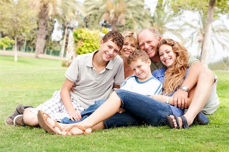 simsearch:400-07426233,k - Family of five relaxing on sunny day in the park and smiling at camera Stock Photo - Budget Royalty-Free & Subscription, Code: 400-04209145