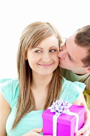 simsearch:400-04739802,k - Attractive boyfriend giving a present and a kiss to his smiling girlfriend against white background Stock Photo - Budget Royalty-Free & Subscription, Code: 400-04209382