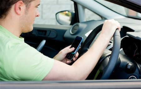 Happy young male driver sitting in a car and holding his phone Stock Photo - Budget Royalty-Free & Subscription, Code: 400-04209833
