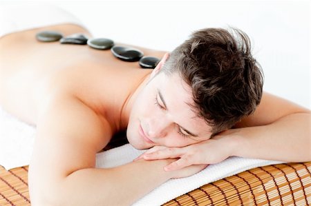 simsearch:400-04192063,k - Resting young man lying on a massage table with hot stone on his back in a health spa Stock Photo - Budget Royalty-Free & Subscription, Code: 400-04209918