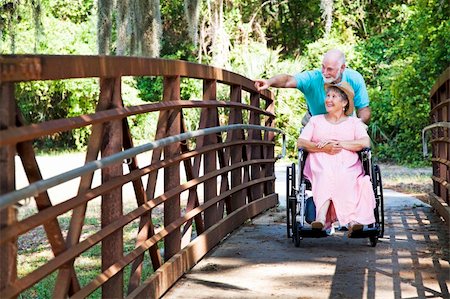 simsearch:400-04208630,k - Senior man pushes his disabled wife's wheelchair through the park. Stock Photo - Budget Royalty-Free & Subscription, Code: 400-04200048